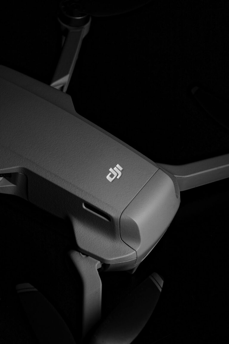 Detailed close-up of a sleek grey drone on a black background, showcasing modern technology.